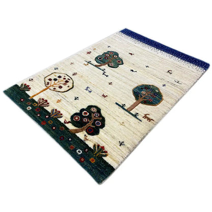 Gabbeh rug in diagonal view: cream base, blue border, tree and flower motifs