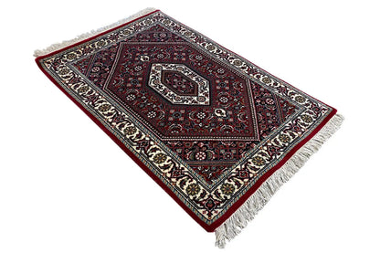 Carpet laid diagonally, red pattern with central medallion, cream border, fringes