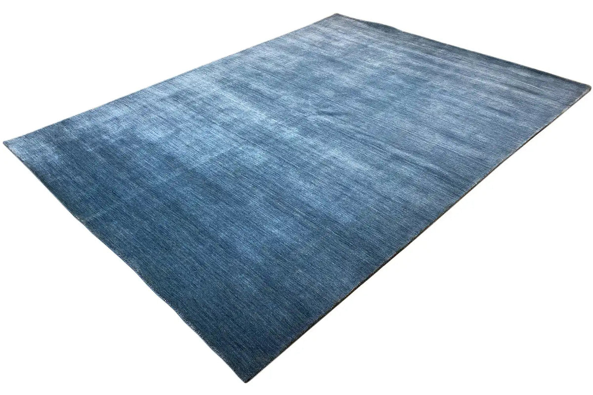 Blue Gabbeh rug at an oblique angle, distinct pile sheen