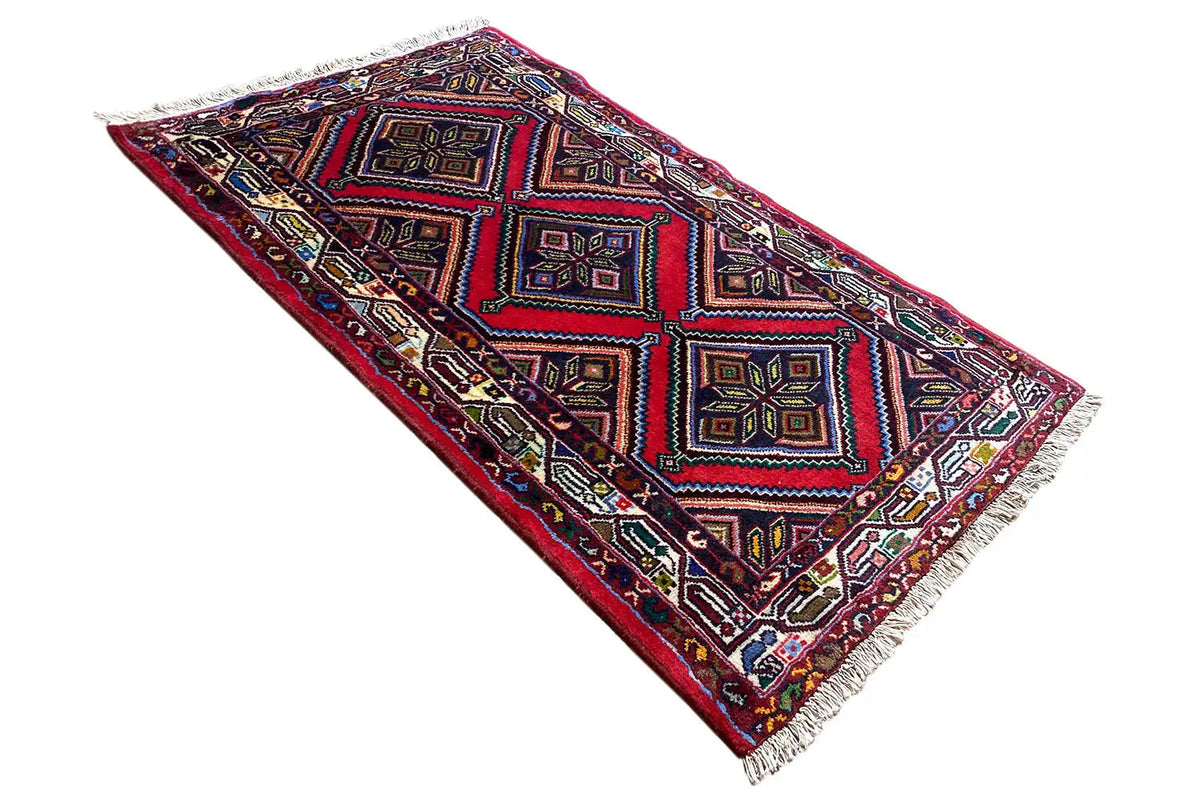 Rectangular rug with multicolored diamonds and squares, fringes along the edges