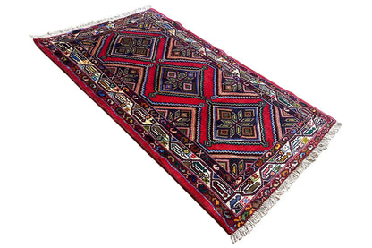 Rectangular rug with multicolored diamonds and squares, fringes along the edges