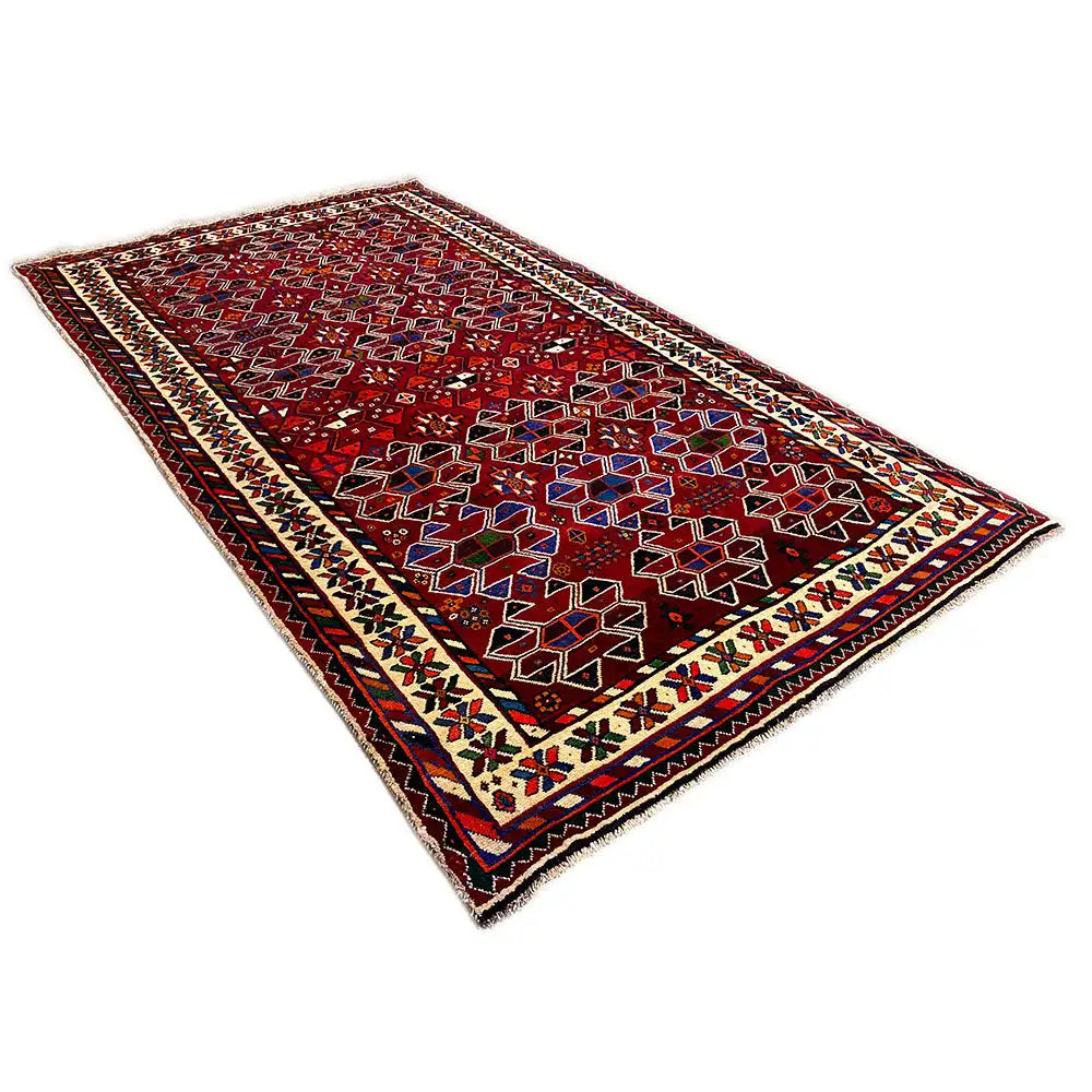 Shiraz rug with a red background, geometric pattern, and framed border