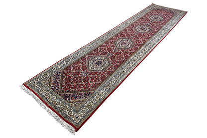 Bidjar runner with a geometric pattern and fringes in red, blue, and beige, angled