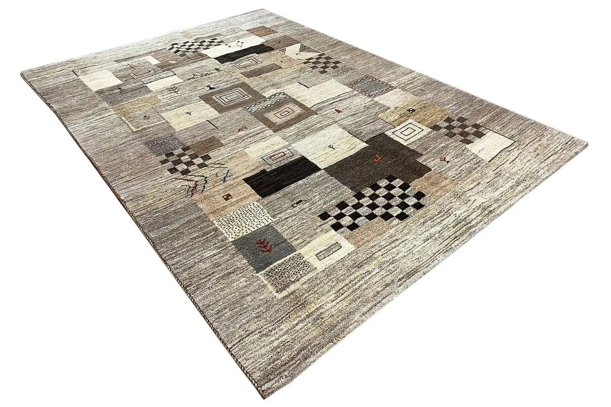 Gabbeh rug, shown at an angle: patchwork of squares and diamonds in gray/beige