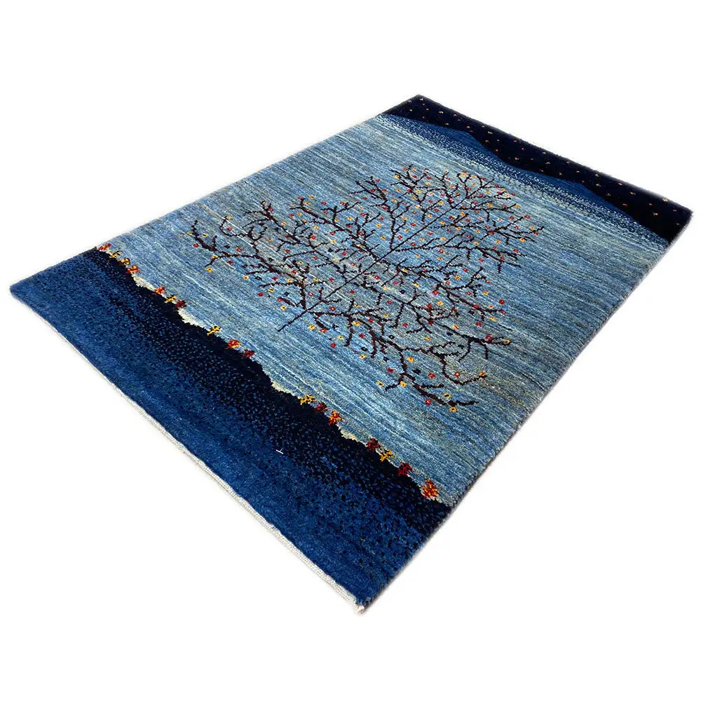 Gabbeh rug spread out with a gray tree crown and colorful trunks, dark borders