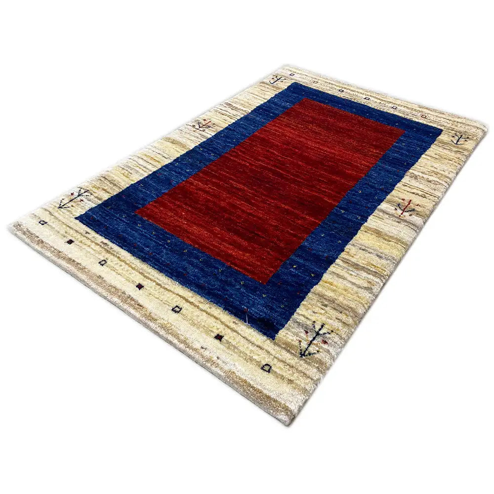 Gabbeh rug, shown at an angle: red rectangle in a blue-framed field on a light background
