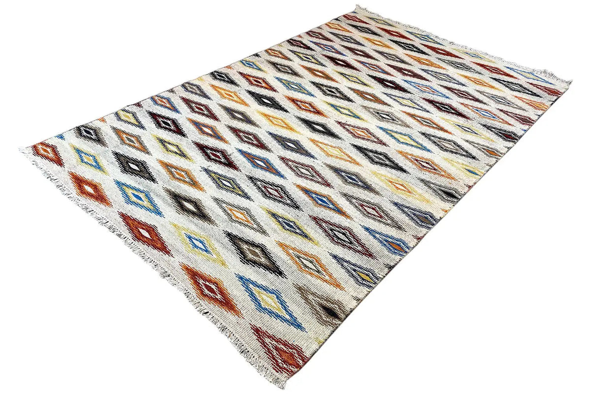 Kelim dhurrie rug at an angle, checkerboard-style diamonds in blue, red, and orange