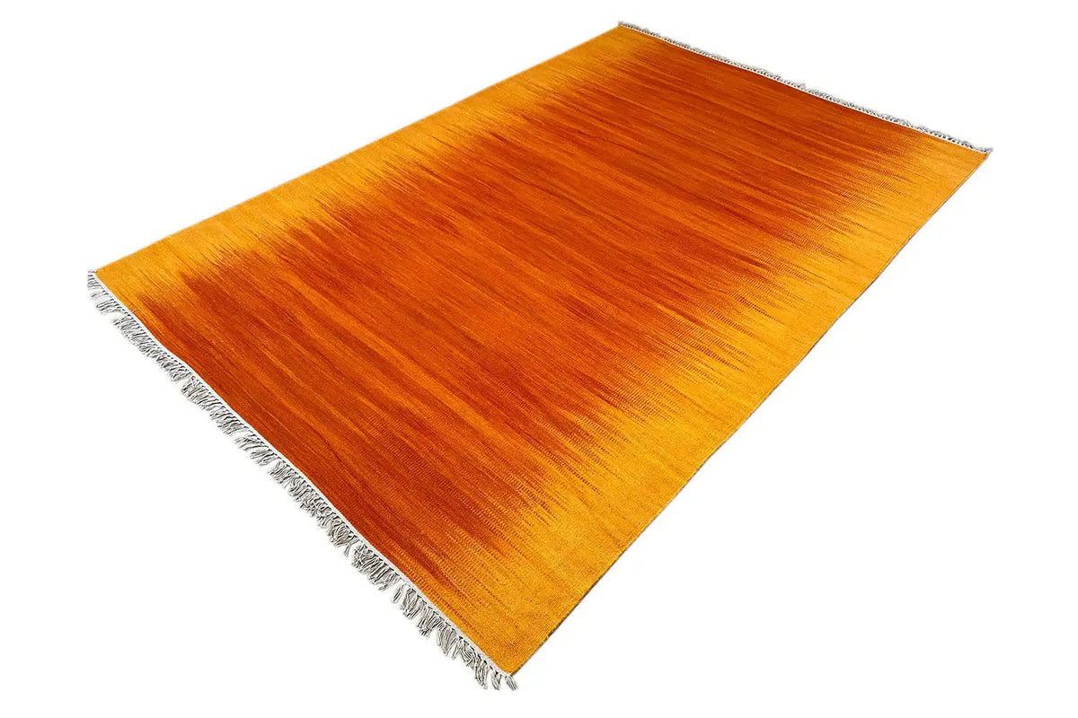 Yellow-orange kilim rug, fringe on two sides, diagonal perspective