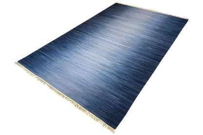Blue kilim rug 160x230 cm with a subtle gradient, gold-colored border, and fringes