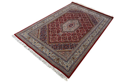 Rug 186x123 cm with red diamond medallion, blue-gray border, and white fringes