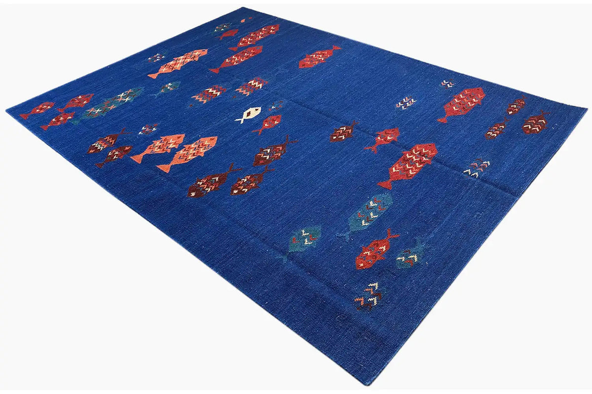 Blue kilim rug with rows of multicolored fish motifs, shown at an angle
