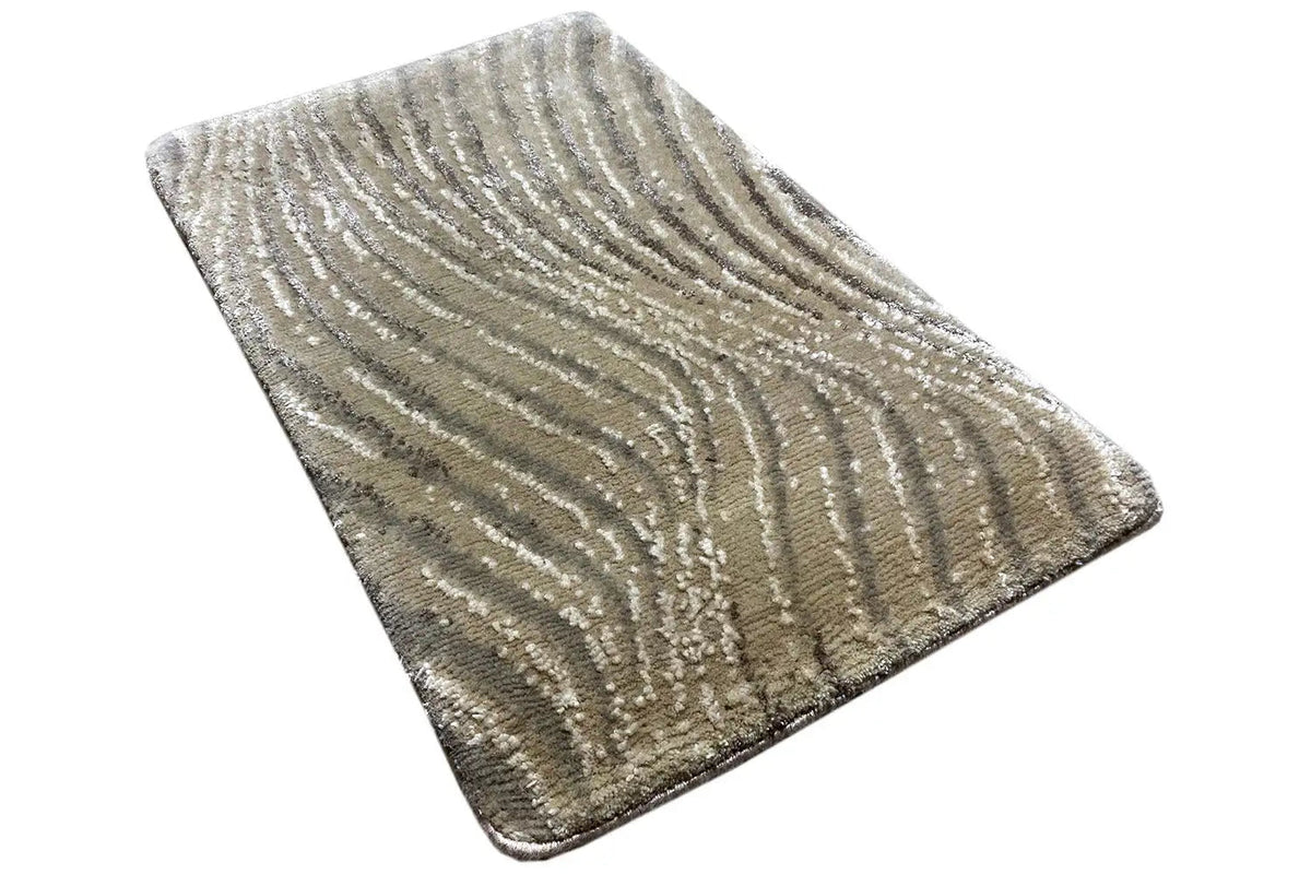 Rectangular rug with shimmering beige and silver-gray wave patterns.
