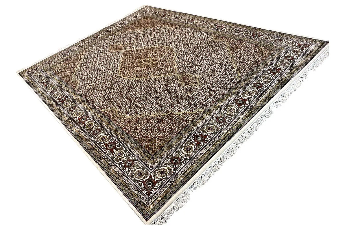 Rug with a central medallion, dark contrasting border, fringes, and an ornamental pattern