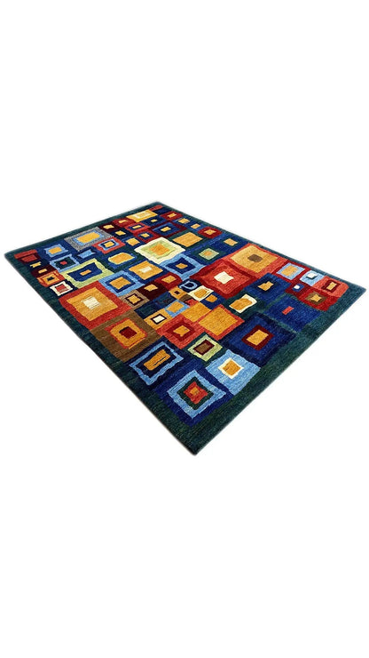 Gabbeh rug, diagonal view, colorful cube and rectangular motifs on dark blue.