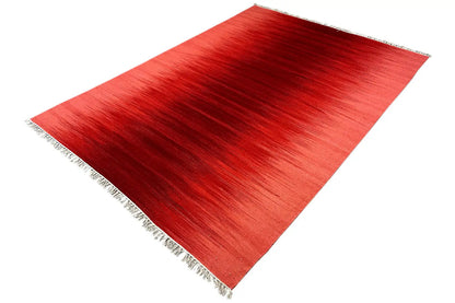 Red kilim rug, angled view of an even pattern and fringes