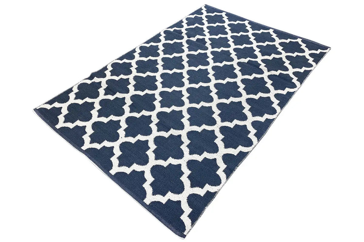 Kilim rug spread diagonally with a dark blue and white geometric pattern