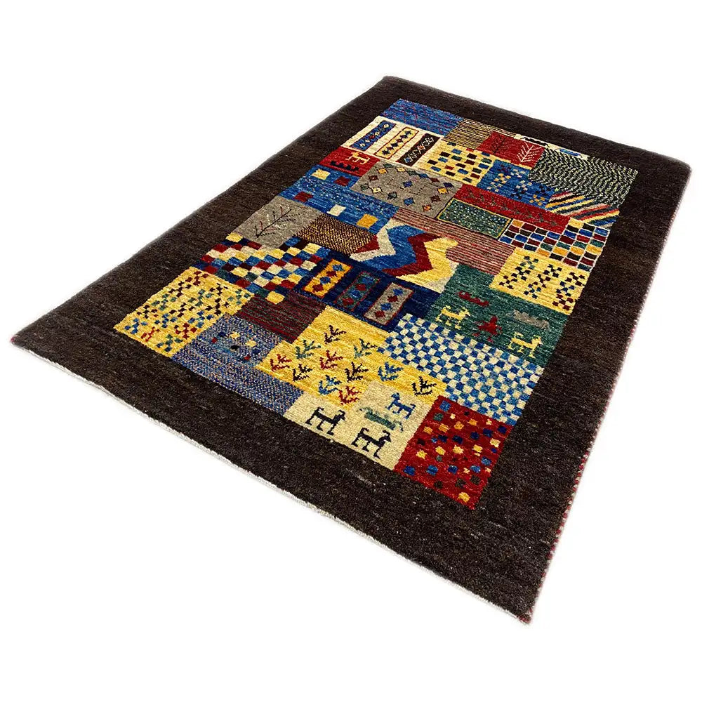 Gabbeh rug with patchwork panels in blue, yellow, and red, and small animal motifs