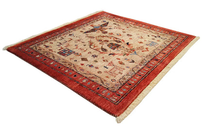 Square rug with a red border, beige field, and decorative figurative pattern.