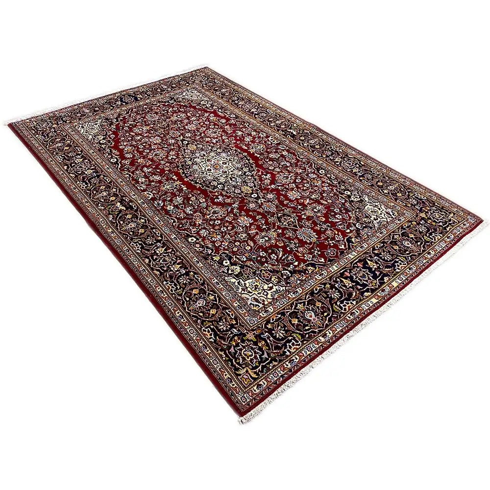 Keshan rug, wine-red field with a central medallion and a dark-bordered ornamental frame.
