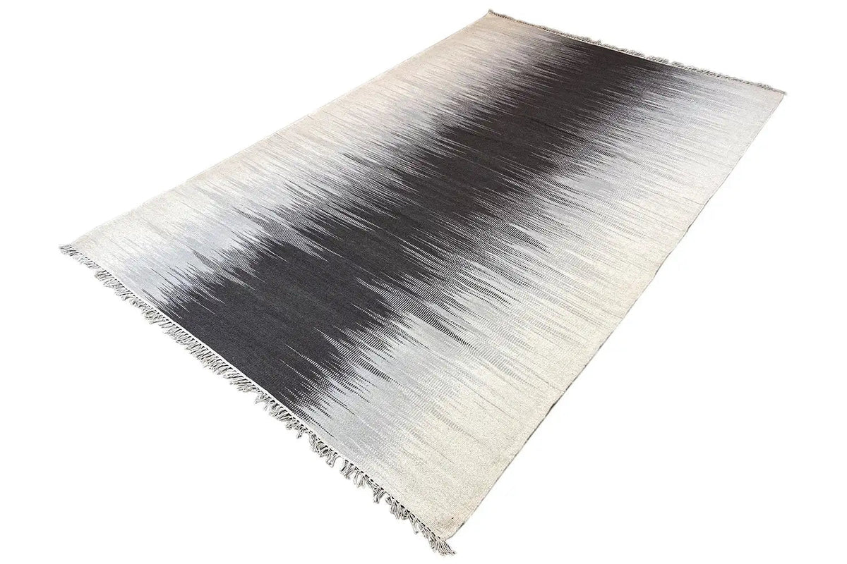Flatweave rug in light gray with a dark central section and side fringes