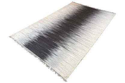 Flatweave rug in light gray with a dark central section and side fringes