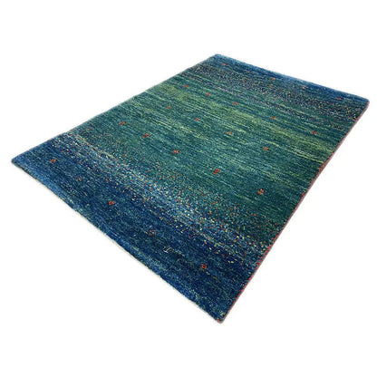 Gabbeh rug 91x63 cm, laid at an angle: green-blue/dark blue with red and yellow accents