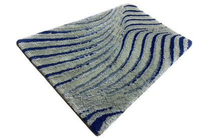 Designer rug corner with a light gray base and dark blue wavy lines, triangular perspective