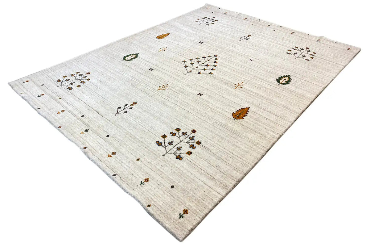 Light beige rug with small floral and leaf motifs, angled view