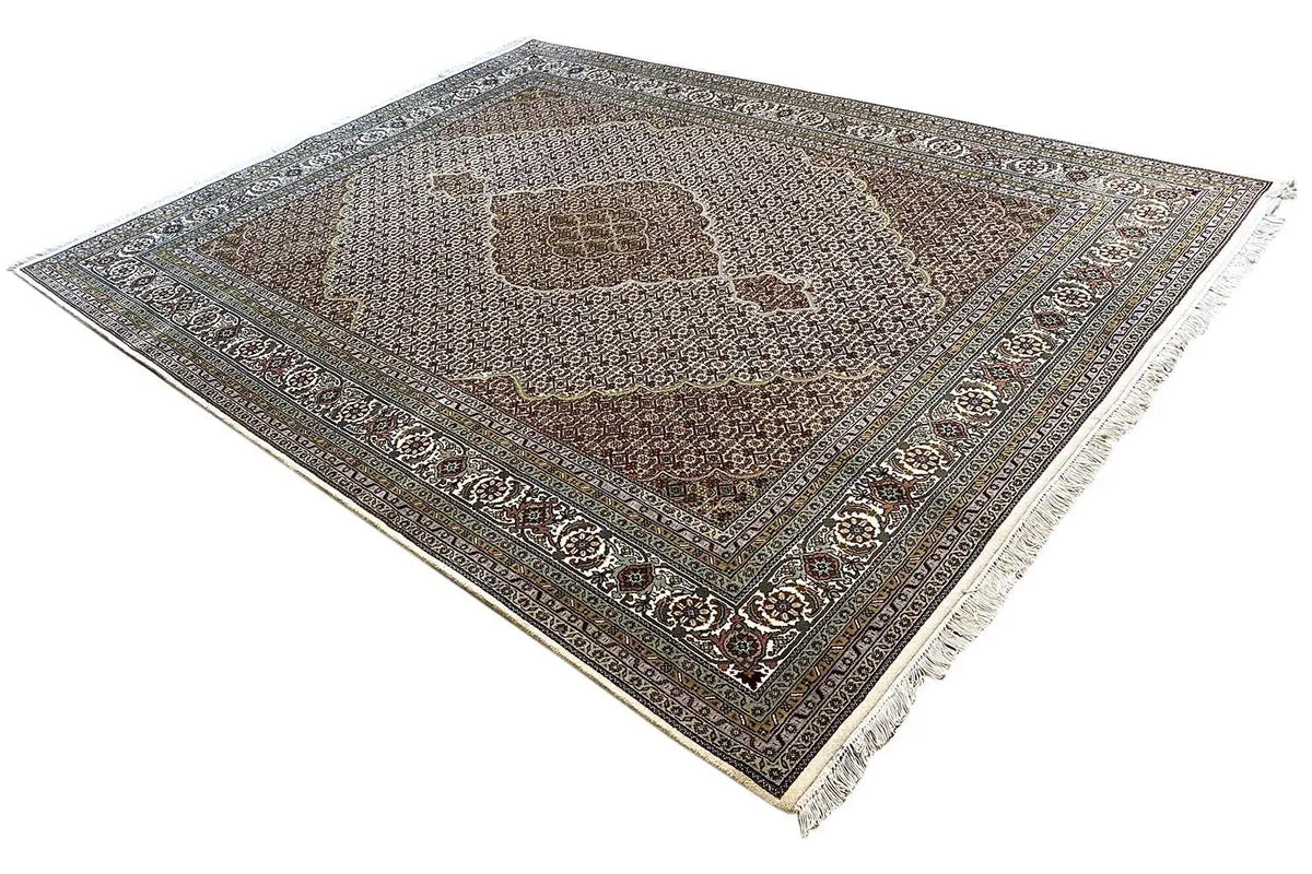 Indo Tabriz rug, diagonal view; muted colors, ornate border and fringes