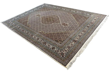 Indo Tabriz rug, diagonal view; muted colors, ornate border and fringes