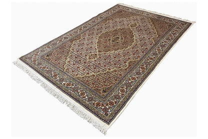 Oriental rug laid flat with a central medallion, dark pile, and white fringes
