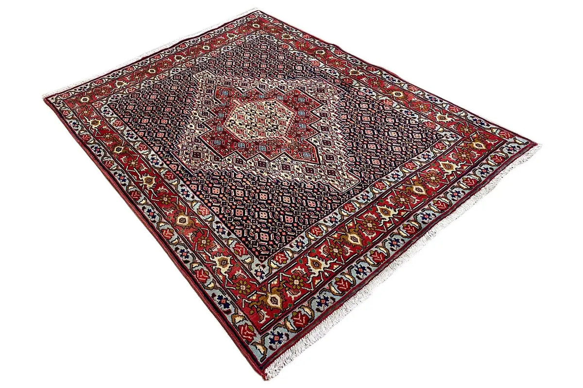 Carpet viewed from above in a diagonal composition, red border and dark base pattern