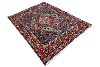 Carpet viewed from above in a diagonal composition, red border and dark base pattern