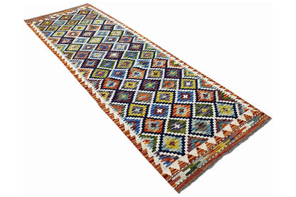 Kilim runner, photographed at an angle, with a multicolored diamond zigzag pattern