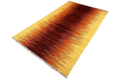 Rectangular kilim rug with a yellow-brown striped gradient and fringes, oblique view