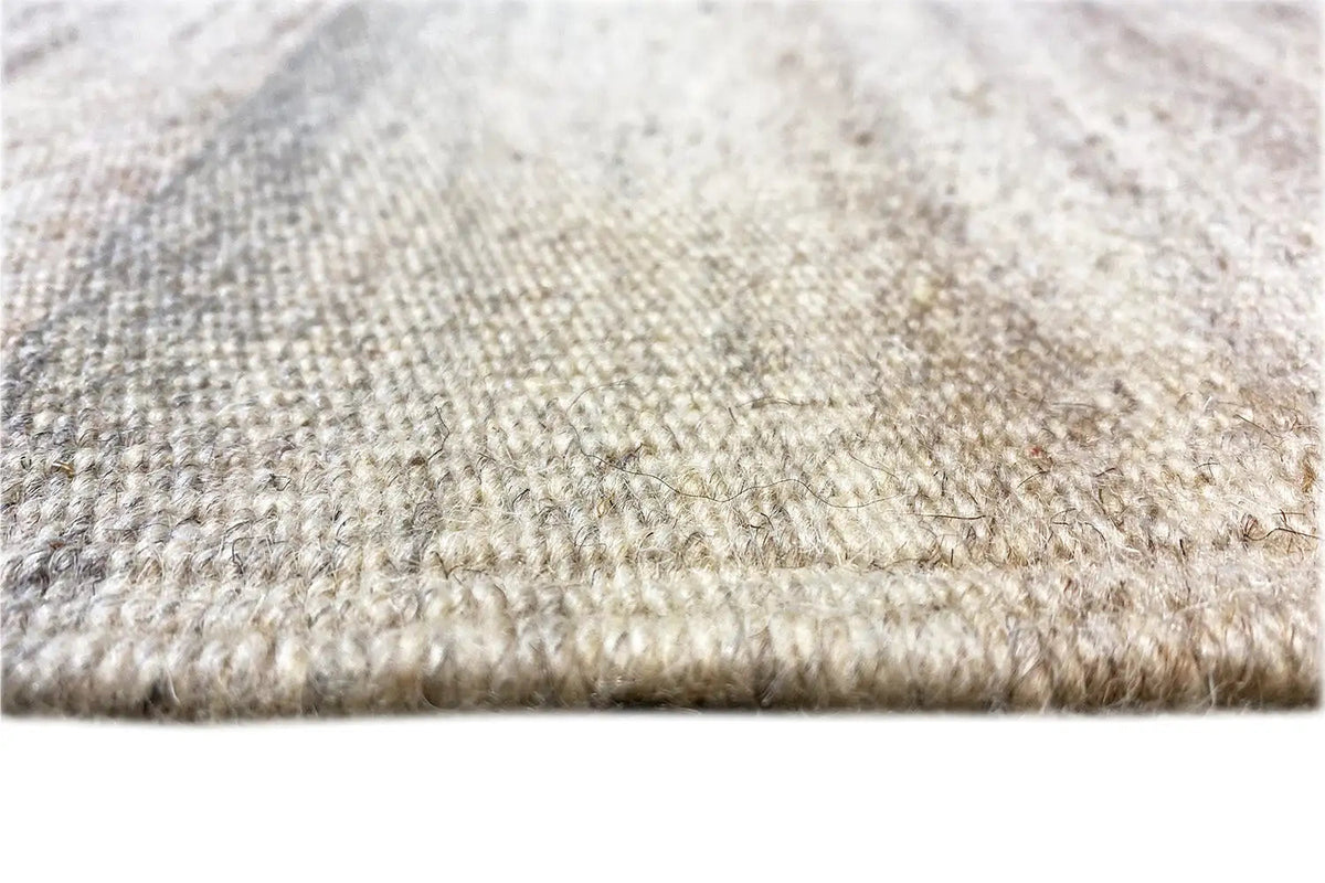Kilim dhurrie rug, light mottled surface with fringes along the edge