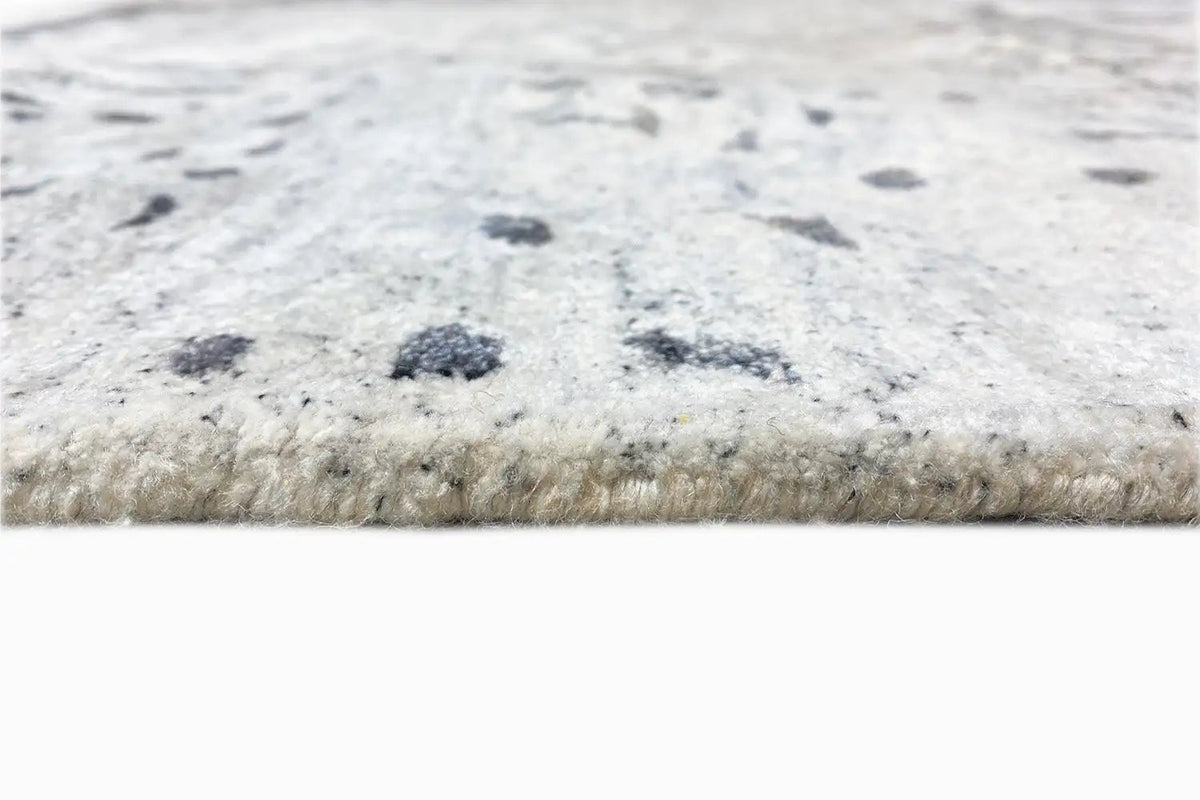 Hand-tufted rug 300x201 cm, close-up of the edge with short fibers and dark speckles