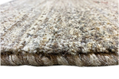 Beige rug with dense textured pile and a visible woven edge