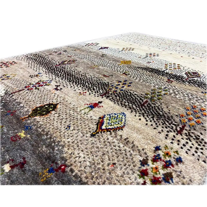 Gabbeh rug detail view: beige pile with colorful, embroidery-like symbols