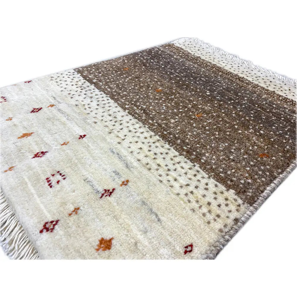 Gabbeh rug, close-up: cream-colored surface with colorful motifs and a brown stripe