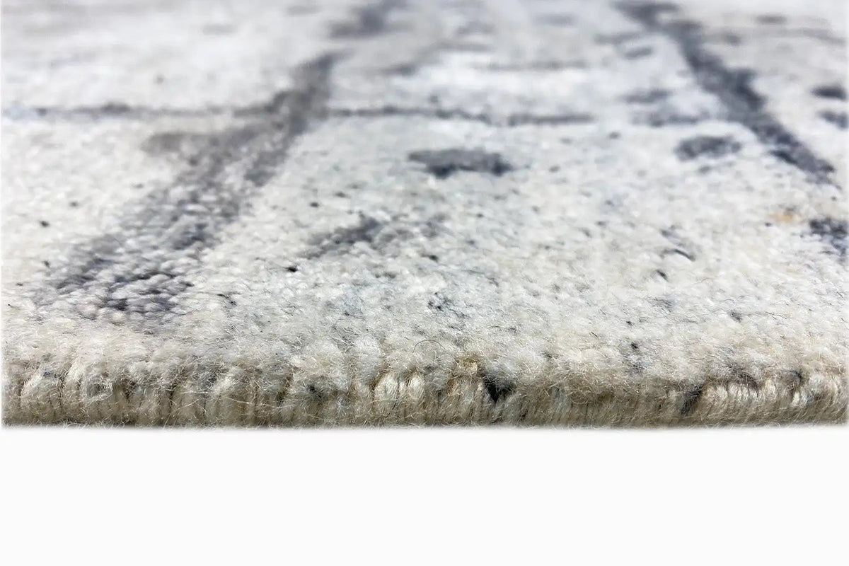 Hand-tufted rug 237x167 cm, detail of the pile height at the edge, light material with dark accents
