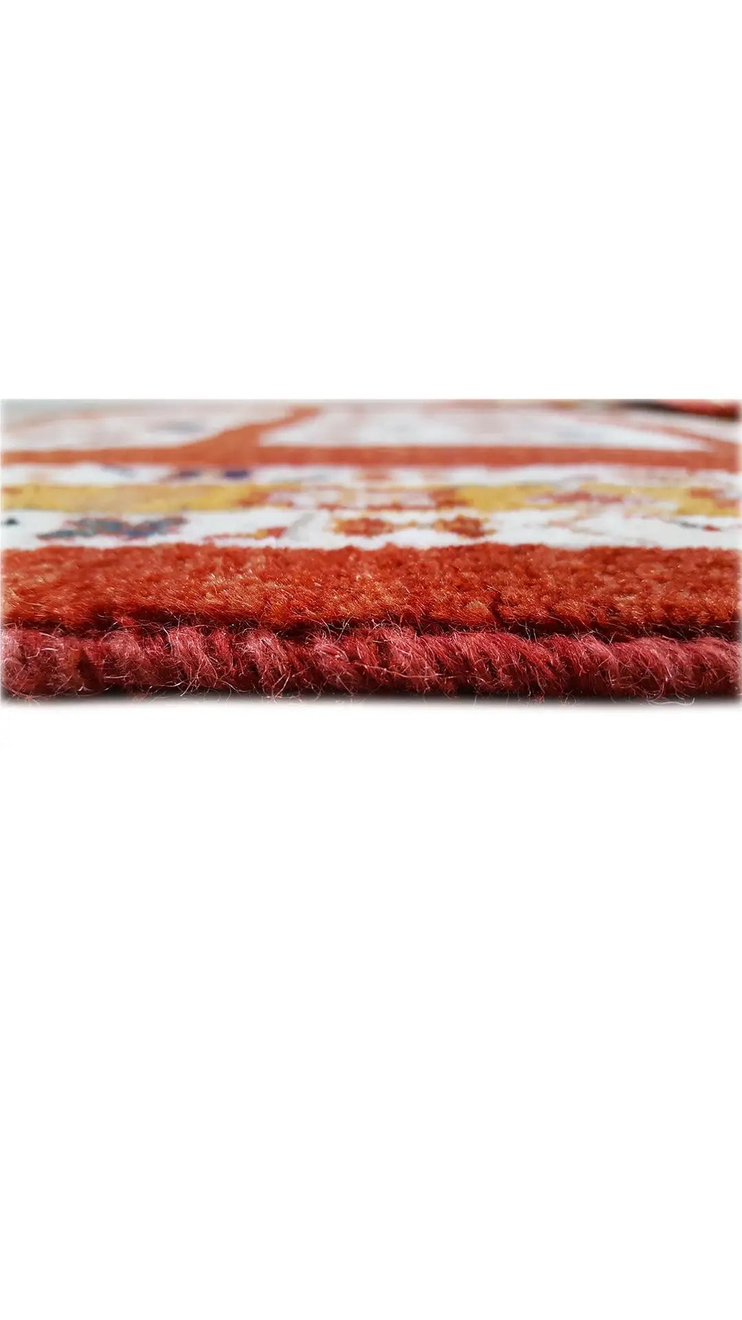 Close-up of the rug edge with a fluffy pile in red and cream.