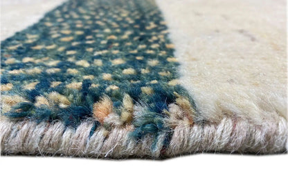 Gabbeh rug detail: pile with blue and beige color accents along the edge