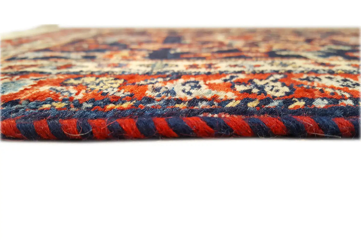 Rug edge with a dense woven texture, multicolored border, and fringes