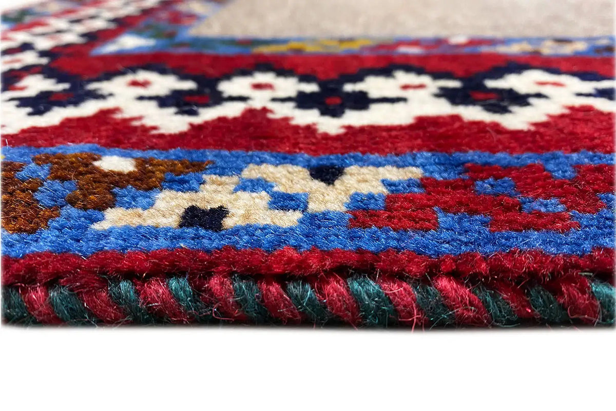 Rug detail: fluffy pile with a multicolored pattern and framed border around the edge