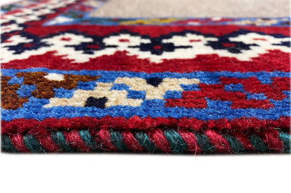 Rug detail: fluffy pile with a multicolored pattern and framed border around the edge