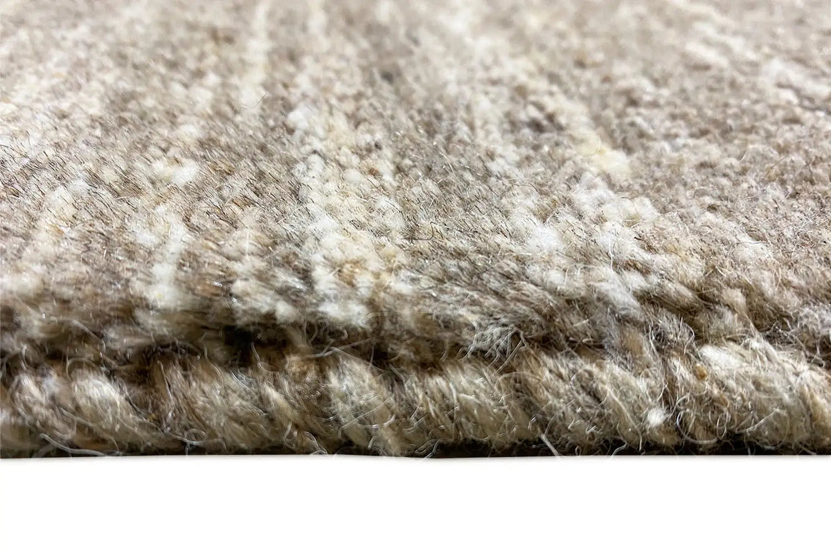 Close-up of the Gabbeh rug: dense beige pile with a visible texture.