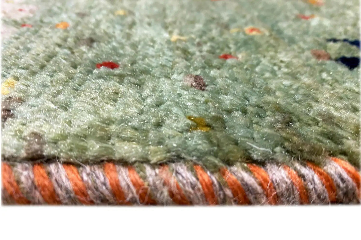 Lori Gabbeh rug: Close-up of the pile with colorful flecks and a fringed edge.