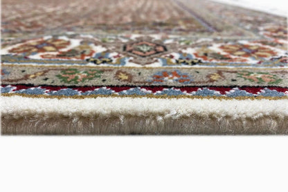 Rug edge with multicolored border design and dense white fringe