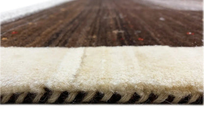 Close-up of a Gabbeh rug: light edge and short fringe, dark pile